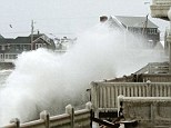 Waves crash into houses on Lighthouse Road during a winter snow storm in Scituate, Massachusetts as an alert was raised over coastal flooding