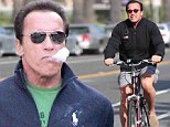 No girly man! Arnold Schwarzenegger rides a bike and is spotted smoking a cigar in a very masculine day