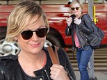 Bed-headed Amy Poehler flashes signature smirk upon landing at LAX ahead of the Golden Globes