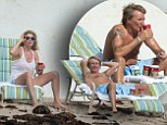 Forever young? Rod seemed to be struggling to keep up with his young family as he washed down pain killers with coffee during beach break in Florida