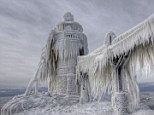 Entombed by the weather: This lighthouse in Michigan resembles a giant icicle after crashing waves were frozen around it by a severe winter storm