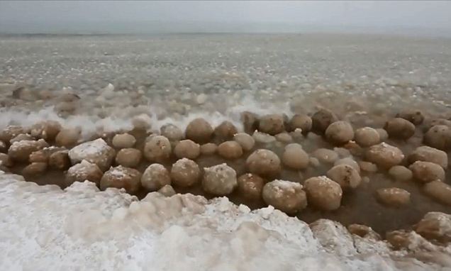 Wow: Hundreds of beach ball-sized ice boulders washed up on the shores of Lake Michigan this week
