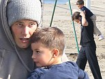 Doting dad Tom Brady gives four-year-old son Benjamin a piggyback ride on the beach in Santa Monica