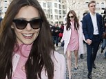 Elizabeth Olsen shows off her toned legs in a pretty pink dress as she clings to boyfriend Boyd Holbrook at Paris Fashion Week