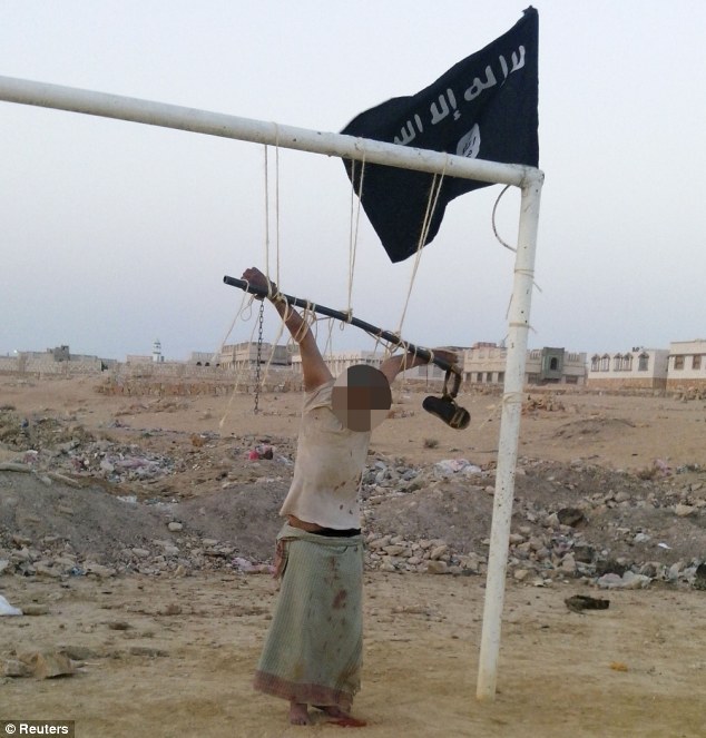 Horror: The body of a man accused of spying for the U.S. is seen tied to a football goal post outside al-Shihr city in Hadhramout, Yemen