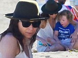 Too much sun today? Minnie Driver takes cover under floppy hat and shades during day at the beach with son Henry