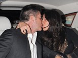 Back-seat smooch! Simon Cowell shares a tender kiss with Lauren Silverman in his car during night out... after buying mag from homeless man