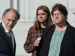Scott Olsen, center, and his attorneys, James Chanin, left, and Rachel Lederman, right, await the start of a news conference at Frank Ogawa Plaza in Oakland,...