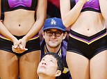 Keeping his head in the game: Joseph Gordon-Levitt peered through two cheerleaders during Los Angeles Lakers game on Sunday