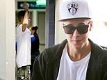 Flying low: Justin Bieber's camouflage trousers fell down dangerously low past his waist to his derriere at LAX on Saturday afternoon