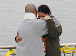 A relative of a passenger aboard the sunken ferry Sewol is consoled by a Buddhist nun, left, as she waits for news on her missing loved one at a port in Jind...
