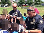 Law enforcers: Officer Matthew Huspek, left, and Officer David McCarthy, pictured at an event last year handing out police stickers, arrested and handcuffed a 9-year-oild girl over a fight