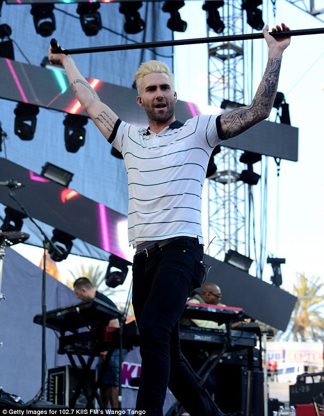 Held high: Adam Levine brandished his mic stand as he performed athletically onstage