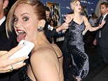 Jennifer Lawrence sticks out her tongue for a fan selfie... before nearly repeating THAT Oscar fall as she loses her balance at X-Men premiere