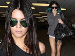 Paris bound?: Kendall and Kylie Jenner jet-set through an LA airport seemingly on their way to France for sister Kim's wedding to Kanye West