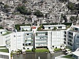 Haves and have-nots: This lavish block of apartments can be seen right next to a sea of tumbledown flats - though residents have blocked off the view