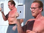 iPumped! Arnold Schwarzenegger shows off his pecs as he takes selfie on tablet during sunbathing session in Cannes