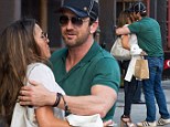 Gerard Butler gives mystery brunette into a tight hug and kisses her on the cheek as the pair make their way into his New York hotel