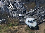 Chilling: An image taken on Monday shows the charred wreckage of the Gulfstream IV that erupted into flames near Boston on Saturday, killing seven