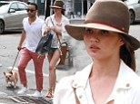 Chrissy Teigen shows off her long legs in tiny denim shorts as she and John Legend enjoy a stroll with their pet pooch
