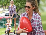 Park Life suits her! Gisele Bundchen flashes pins in denim hotpants as she dotes on daughter Vivian who cycles on her trike alongside husband Tom Brady