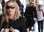 Madonna cuts an unusually demure figure in black jacket and cropped trousers as she jets into NYC with daughter Mercy