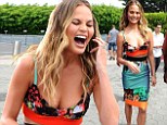 Chrissy Teigen leaves little to the imagination in racy low-cut ensemble as she larks around on Extra