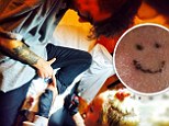 Miley ink! Cyrus and assistant Cheyne Thomas tattoo each other... but singer only manages a rather simplistic smiley face