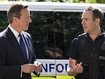 SLOUGH, ENGLAND - JULY 29:  British Prime Minster David Cameron (L) speaks to Paul Wylie, Director for London & South region of Home Office Immigration Enforcement, at a property where six immigrants were arrested on July 29, 2014 in Slough, England. The arrested individuals, who are suspected of residing in the UK illegally, were taken to an immigration detention facility pending their removal from the UK. The Government has announced it is to reduce the time EU migrants without realistic job prospects are able claim benefits from six to three months.  (Photo by Oli Scarff - WPA Pool /Getty Images)