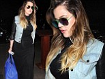Khloe Kardashian slenderizes her curves in a form-fitting black dress as she rushes to catch a flight out of LAX