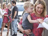 Keeping him close! Hilary Duff carries son Luca while flashing her pins in cute red dress following dinner with estranged husband Mike Comrie
