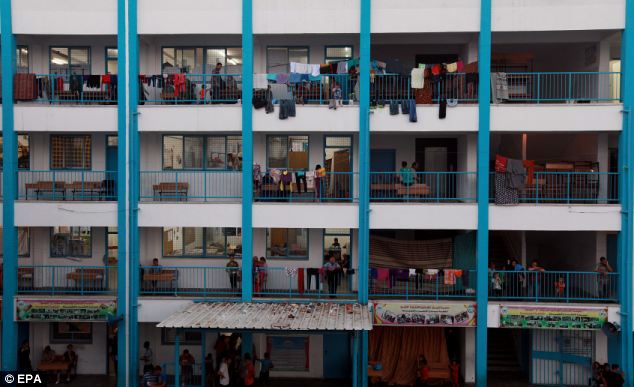 Palestinian families take shelter at a United Nations (UN) school in central Gaza City which was attacked by Israeli forces on Sunday