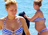 Bumpin' and proud: Hayden Panettiere showed off her growing belly in a striped bikini as she holidayed in Miami, Florida on Saturday