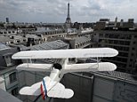 A seventy five percent size replica of the L'Oiseau Blanc biplane is seen on the terrace of the restaurant and bar LíOiseau Blanc located on the sixth floor of the the Peninsula Paris luxury hotel in Paris July 30, 2014. After four years of refurbishment work costing 430 million euros, the Peninsula Paris hotel opens its doors on Friday, promising prince-like treatment to well-heeled visitors to the French capital. The new hotel located in a 1908 building a stone's throw from the Arc de Triomphe and Champs Elysees, will offer rooms starting a just over 1,000 euros a night and rising to 25,000 euros for a penthouse suite with its own roof-top garden. Each of its 200 rooms allows guests to make free phone calls anywhere in the world and is fitted with a printer, coffee machine, a nail-dryer and a tablet centralising all functions from dimming the lights to ordering breakfast. On the background the Eiffel Tower. Picture taken July 30, 2014. REUTERS/Benoit Tessier  (FRANCE - Tags: BUSINES