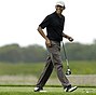 This Aug. 12, 2013 photo shows President Barack Obama as he steps onto a tee while golfing at Vineyard Golf Club in Edgartown, Massachusetts, on the island of Martha's Vineyard, during his vacation there last summer. The White House says the president plans to return to Martha's Vineyard tomorrow regardless of the situation in Iraq