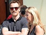 Michael Fassbender shows off his muscular arms as he pulls a Bono by wearing rose-tinted sunglasses for a day out in NYC with a blonde companion