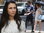 Famke Janssen keeps shaded from UV rays under frilly 'sunbrella' on stroll with longtime love Cole Frates and their dog