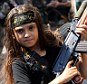 'Victory': A Palestinian girl holds a Kalashinkov as Islamist fighters celebrate what they call a 'victory' over Israel following Tuesday's ceasefire