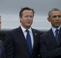 U.S. President Barack Obama, right, points as he stands alongside British Prime Minister David Cameron, centre, and NATO Secretary General Anders Fogh Rasmussen during a flypast at the NATO summit at the Celtic Manor Resort in Newport, Wales on Friday, Sept. 5, 2014. (AP Photo/Jon Super)
