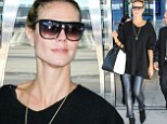 She's working the airport runway! Heidi Klum displays her slender legs in skintight leather pants as she jets into JFK