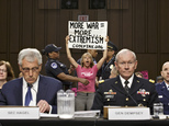 Members of the anti-war activist group CodePink interrupt a Senate Armed Services Committee hearing with Defense Secretary Chuck Hagel, left, and Army Gen. Martin Dempsey, chairman of the Joint Chiefs of Staff, on Capitol Hill in Washington, Tuesday, Sept. 16, 2014.  It is the first in a series of high-profile hearings that will measure congressional support for President Barack Obama's strategy to combat Islamic State extremists in Iraq and Syria.  (AP Photo/J. Scott Applewhite)