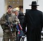 Police officers and French army soldiers patrol Rue des Rosiers street,  in the heart of Paris Jewish quarter, in Paris, Monday Jan. 12, 2015. France on Monday ordered 10,000 troops into the streets to protect sensitive sites after three days of bloodshed and terror, amid the hunt for accomplices to the attacks that left 17 people and the three gunmen dead. (AP Photo/Remy de la Mauviniere)