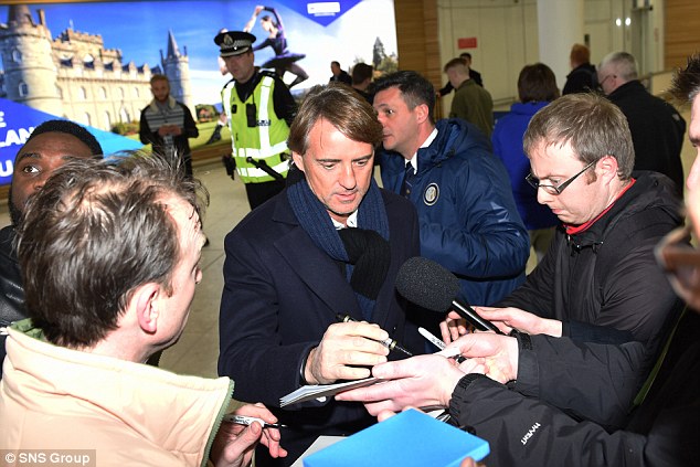 Roberto Mancini arrives in Glasgow and is mobbed by fans and members of the press
