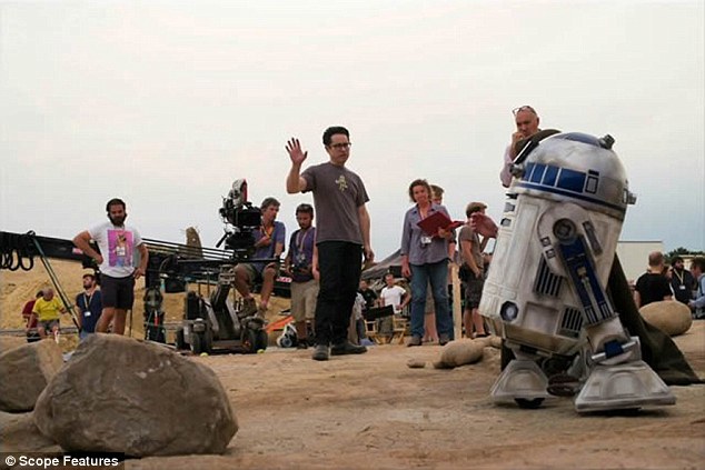 On set: Abrams talking to his team as they look at the R2D2 unit