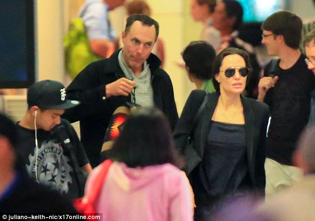 United: Angelina's older sibling James dressed in a grey pullover, black coat and denim jeans