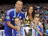 Terry smiles for the cameras as he holds the Premier League trophy with his wife and two children