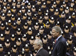 FILE - In this Dec. 29, 2014 file photo, New York City Mayor Bill de Blasio, right, and NYPD police commissioner Bill Bratton, center, stand on stage during a New York Police Academy graduation ceremony at Madison Square Garden in New York. Mayor de Blasio has spent much of the week answering questions about a 9 percent spike in crime in New York. But experts say that a major rise in crime, which hasn't happened yet during his administration, would be more damaging to him than other mayors since he had a reputation for being soft on crime, his relationship with the police is tenuous and so much of his plan to change the justice system is hinged on the idea that crime will not rise. (AP Photo/John Minchillo, File)