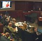 Defendant James Holmes appears in a video presented to a darkened courtroom in Centennial, Colo., Thursday, June 4, 2015. Holmes, also seated at defense table below screen, spoke in the video to a psychiatrist who evaluated him for the trial on charges that he killed 12 people and wounded 70 others during the midnight premiere of a Batman film. (Colorado Judicial Department via AP, Pool)