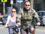 UK CLIENTS MUST CREDIT: AKM-GSI ONLY
EXCLUSIVE: Former California Governor and actor Arnold Schwarzenegger and his girlfriend enjoy a beautiful day in Santa Monica by biking around town.  Arnold wore a camouflaged jacket with matching slip ons, while his girlfriend trailed behind him in a white t-shirt and navy blue cropped leggings.

Pictured: Arnold Schwartzenegger
Ref: SPL1048110  070615   EXCLUSIVE
Picture by: AKM-GSI / Splash News