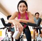 A woman in a spinning class on an exercycle in a gym / health club.